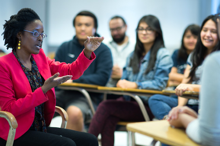 female advisor speaks to seated students in classroom