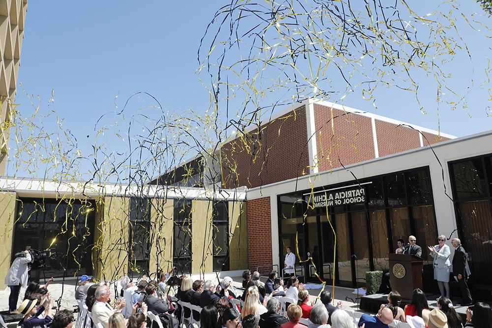 The crowd cheers as black and gold streamers shoot into the air after the officially naming of the school. 