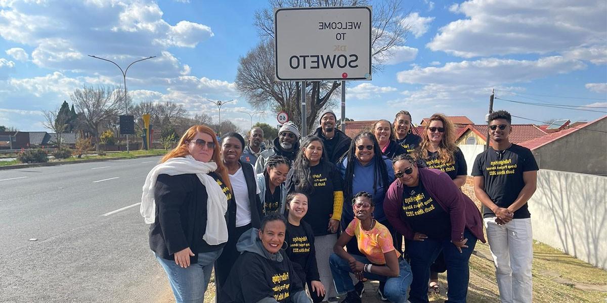  Fulbright-Hays GPA summer 2023 participants some kneeling, others st和ing in frony of Welcome to Soweto Sign inSoweto Township, 南非 