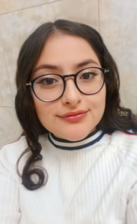 Woman with dark brown hair wearing glasses and a white sweater